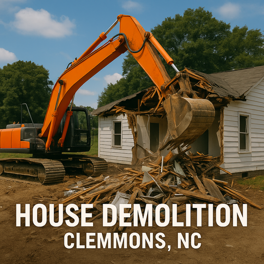 Orange excavator removing rubble during a house demolition project in Clemmons, North Carolina.